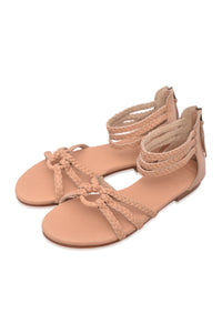 Pair of beige sandals with braided straps on a white background