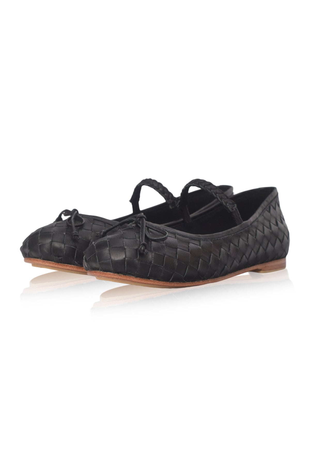 A pair of black woven leather ballet flats with braided ankle straps and small bow details, displayed on a clean white background with a soft reflection.