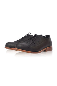 A pair of black leather wingtip oxford shoes with brogue detailing and black laces, shown on a clean white background with a soft reflection.
