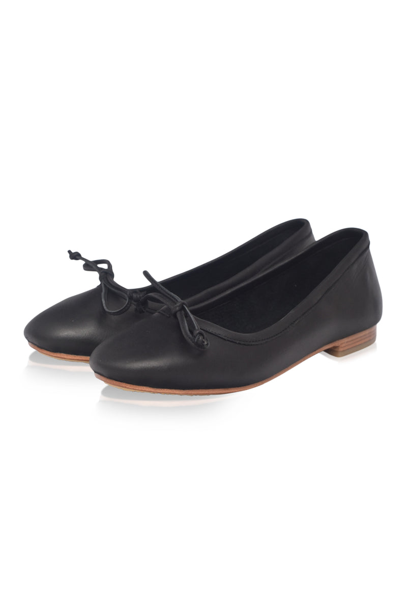 Pair of black leather shoes with a bow on a white background