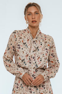 Woman wearing a floral patterned blouse against a white background