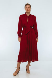 Woman wearing a burgundy dress on a white background