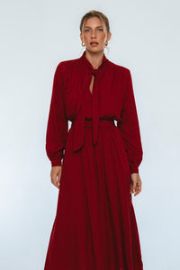 Woman wearing a burgundy dress against a white background