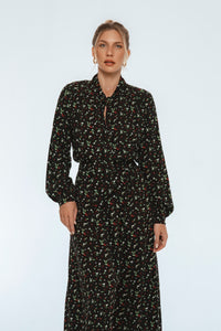 Woman wearing a black floral dress on a white background
