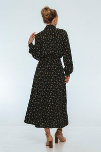 Woman wearing a black floral dress on a white background