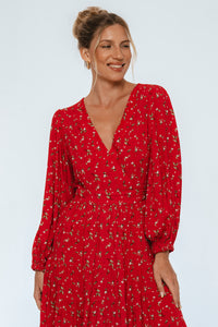 Woman wearing a red dress with a subtle pattern on a white background