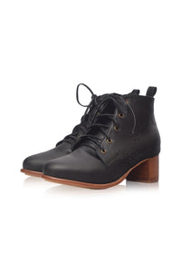 A pair of black leather lace-up ankle boots with a chunky brown block heel and brass eyelets, shown on a clean white background.