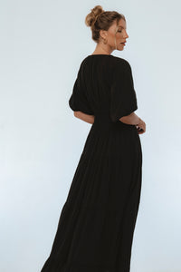 Woman wearing a black dress against a white background