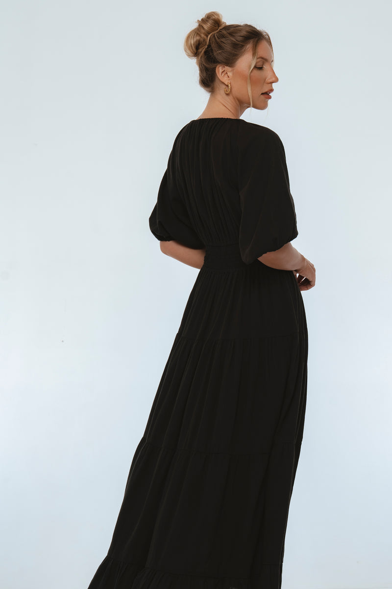 Woman wearing a black dress against a white background