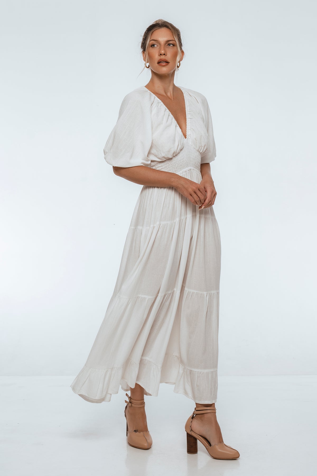 Woman wearing a white dress with a plain background