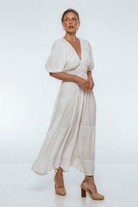 Woman wearing a white dress with a plain background