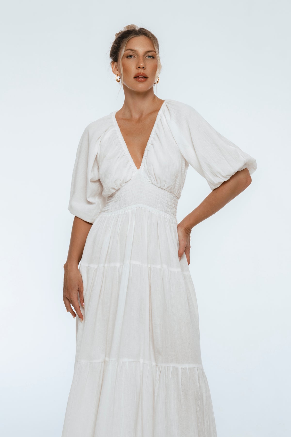Woman wearing a white dress with a plain background