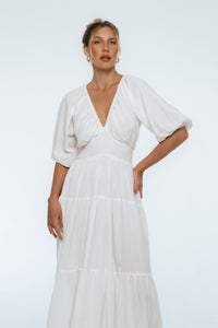 Woman wearing a white dress with a plain background