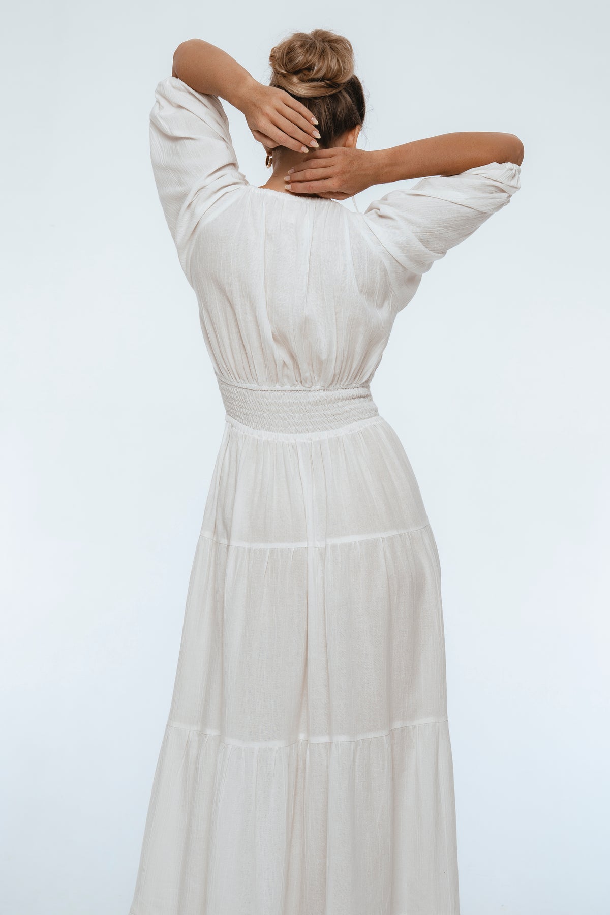 Woman wearing a white dress with a plain background