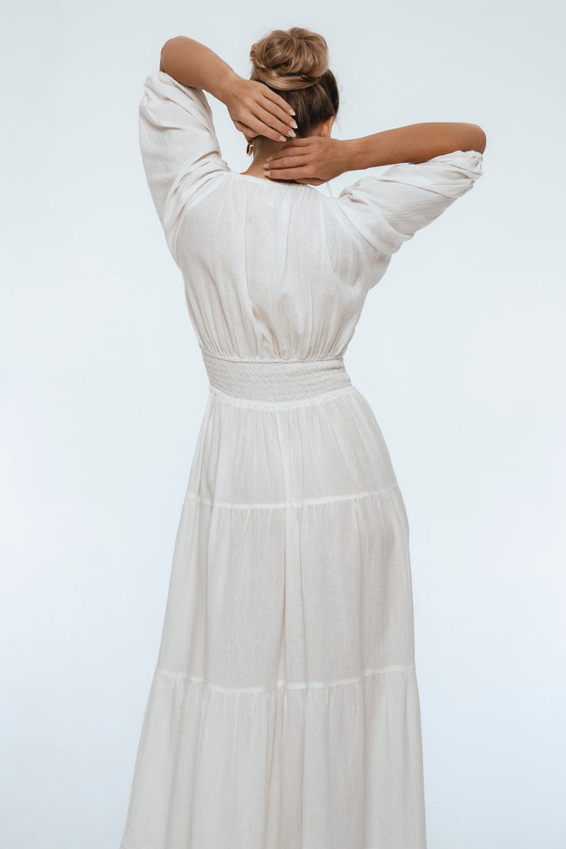 Woman wearing a white dress with a plain background