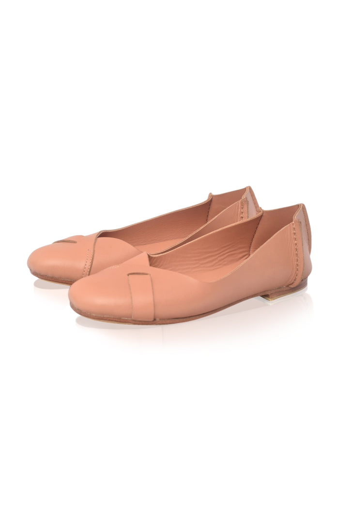 A pair of women's leather ballet flats in a warm peachy-beige color, featuring a decorative strap across the toe, shown on a clean white background.