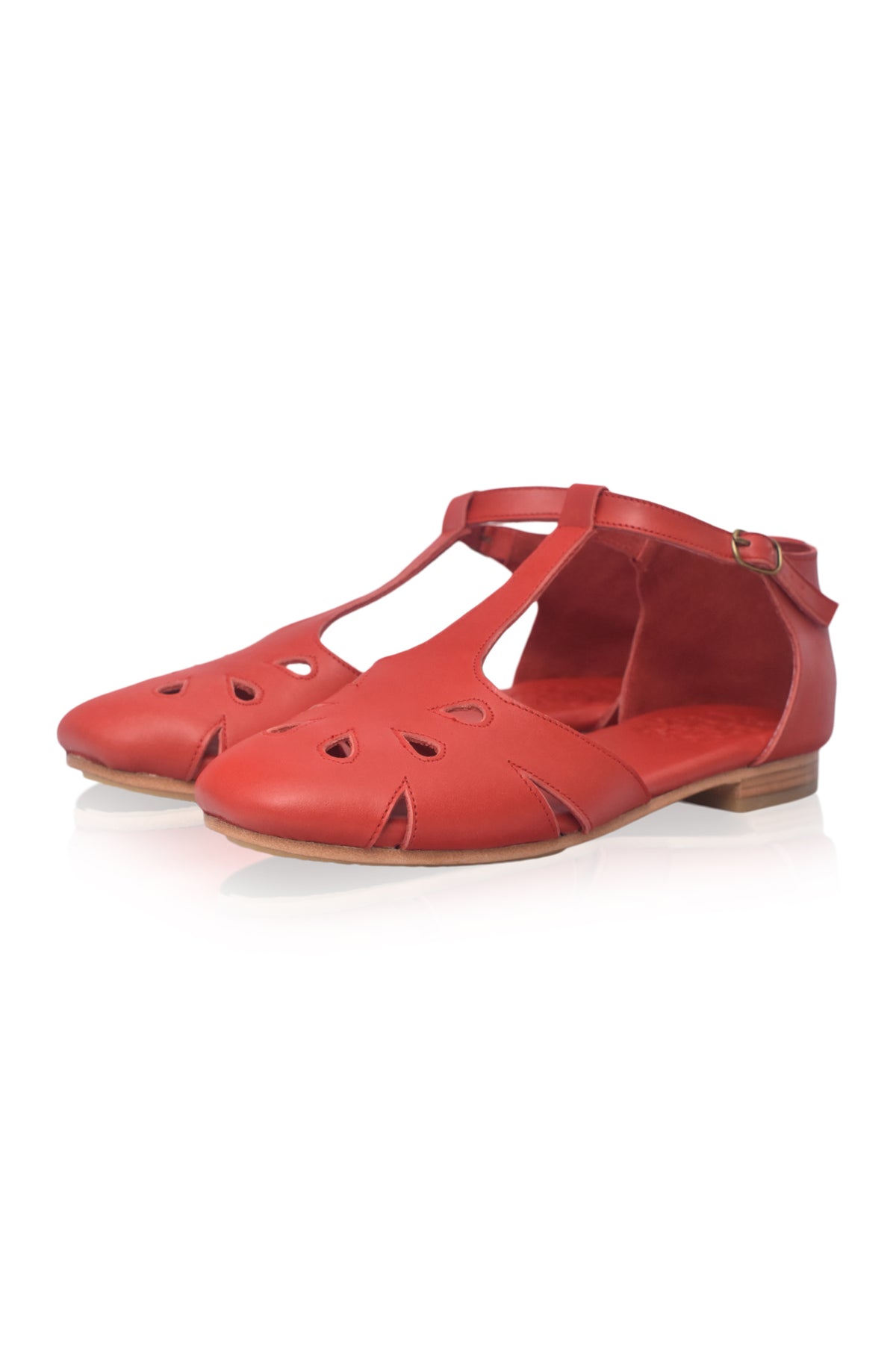 A pair of red leather T-strap sandals with cutout details on the toe and sides, shown against a plain white background.