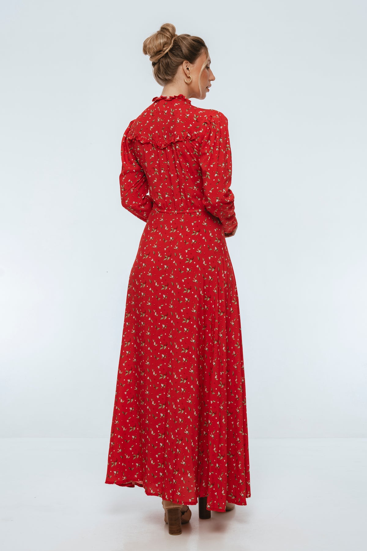 Woman wearing a red floral dress on a white background