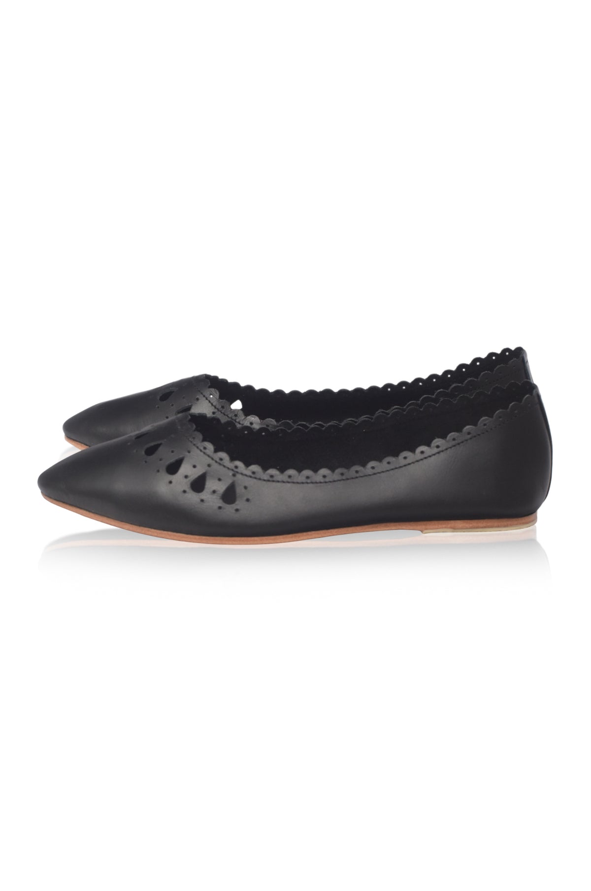 A pair of black leather ballet flats with pointed toes, decorative perforations, and a scalloped edge, shown against a plain white background.