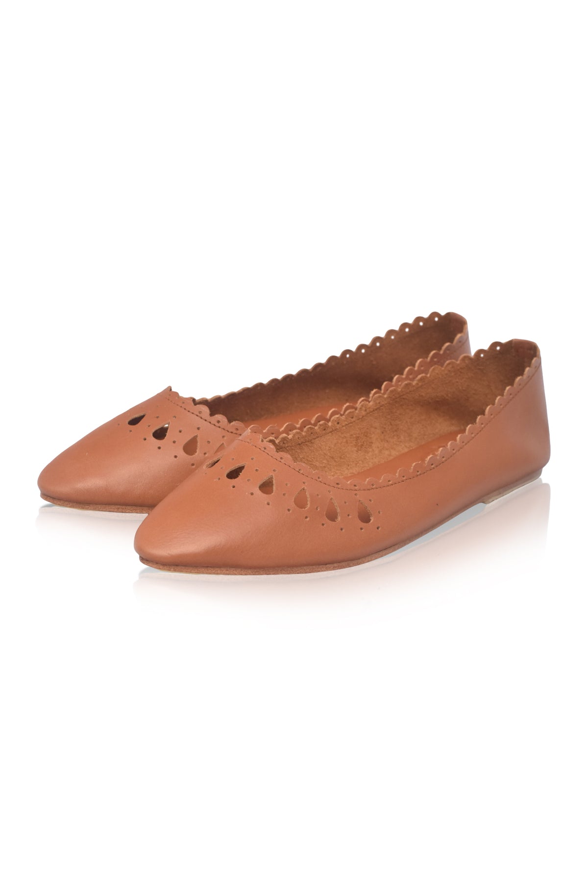 A pair of tan leather ballet flats with pointed toes, decorative heart-shaped cutouts, and scalloped edges, shown on a white background.