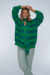 Woman wearing a green and blue striped sweater on a white background