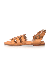 Tan sandal with decorative straps on a white background