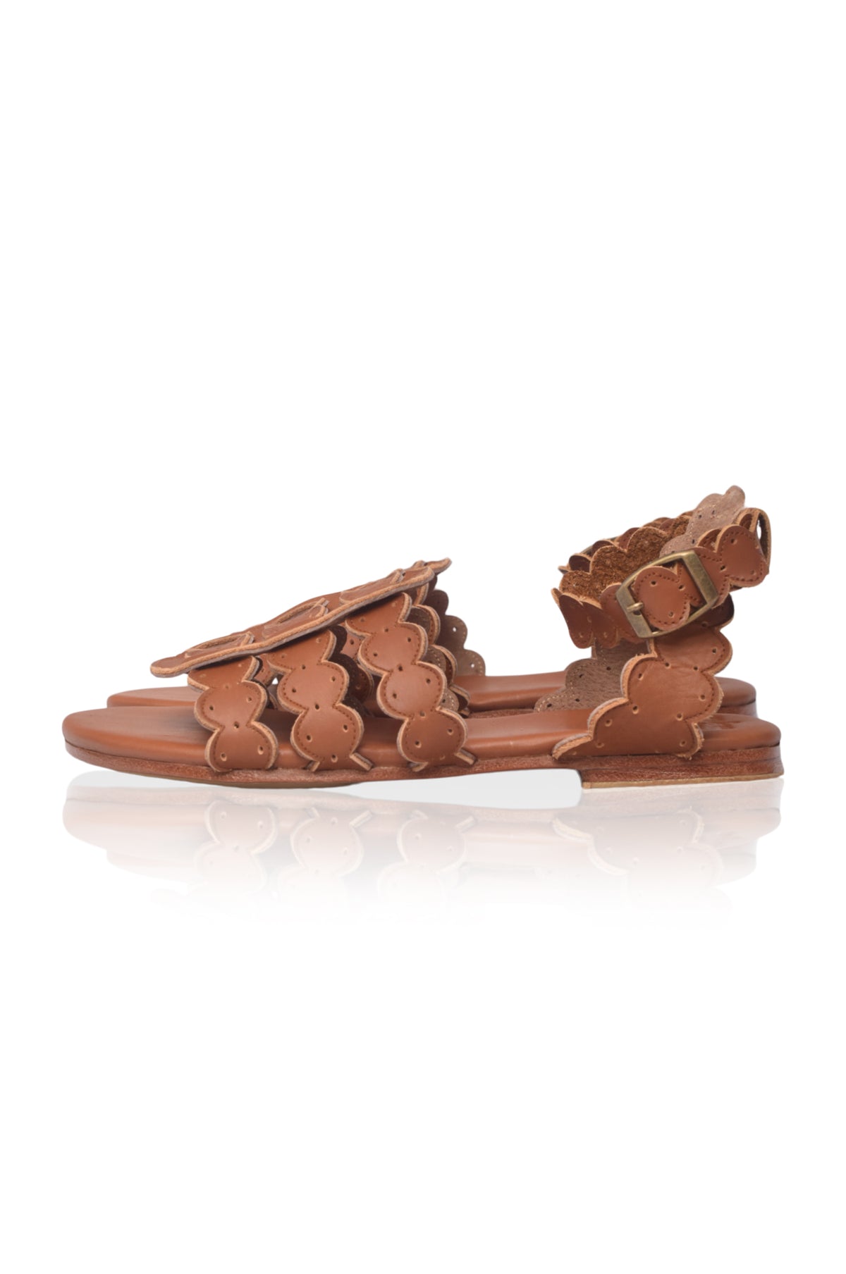 Brown sandal with decorative straps on a white background