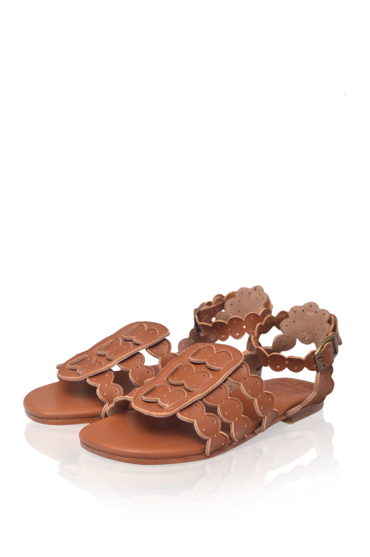 Brown sandal with floral cut-out design on a white background