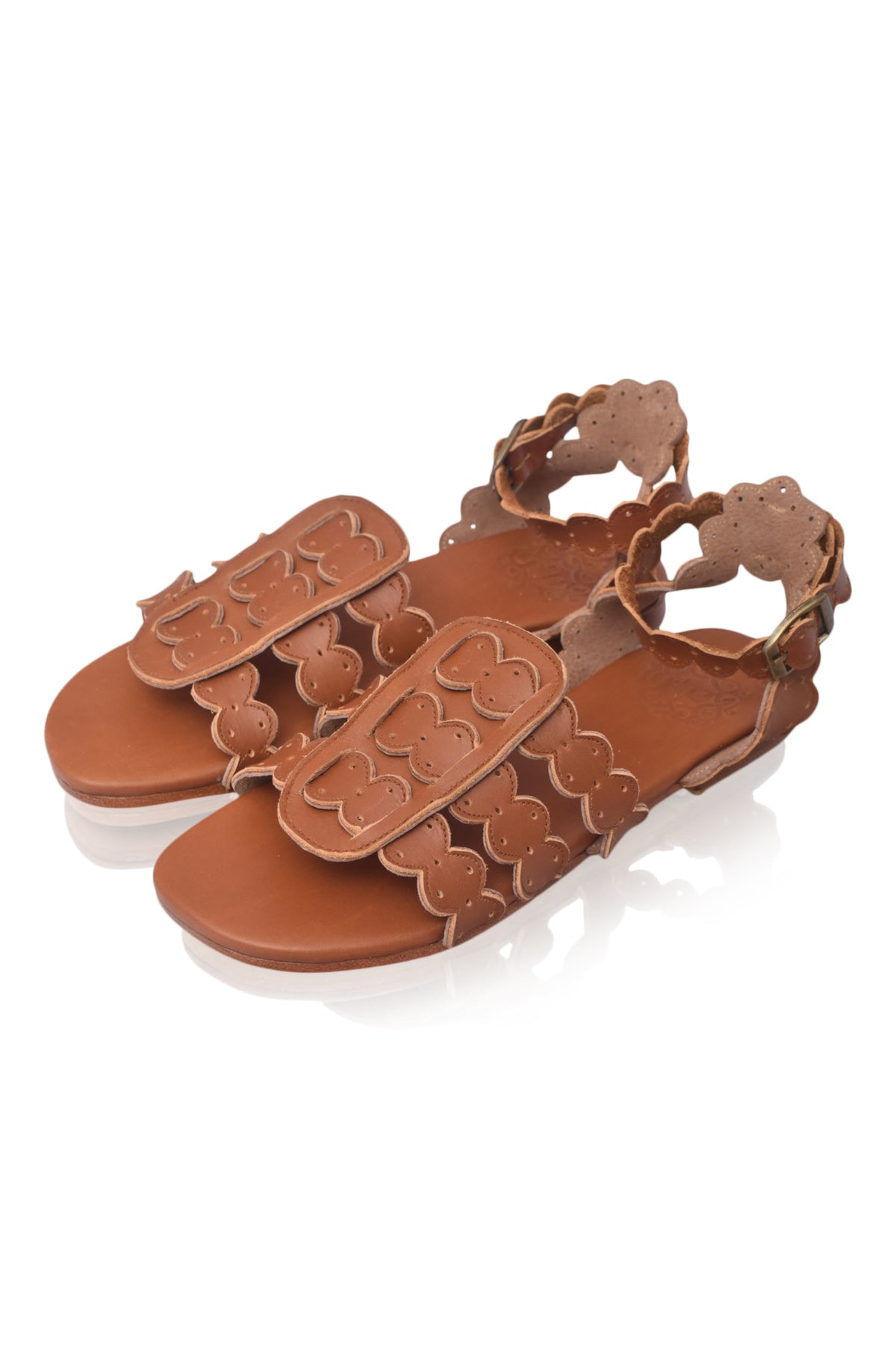 Brown sandal with decorative straps on a white background