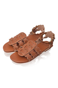 Brown sandal with decorative straps on a white background