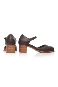 A pair of dark brown leather Mary Jane style shoes with block heels, shown from the side and back on a white background.