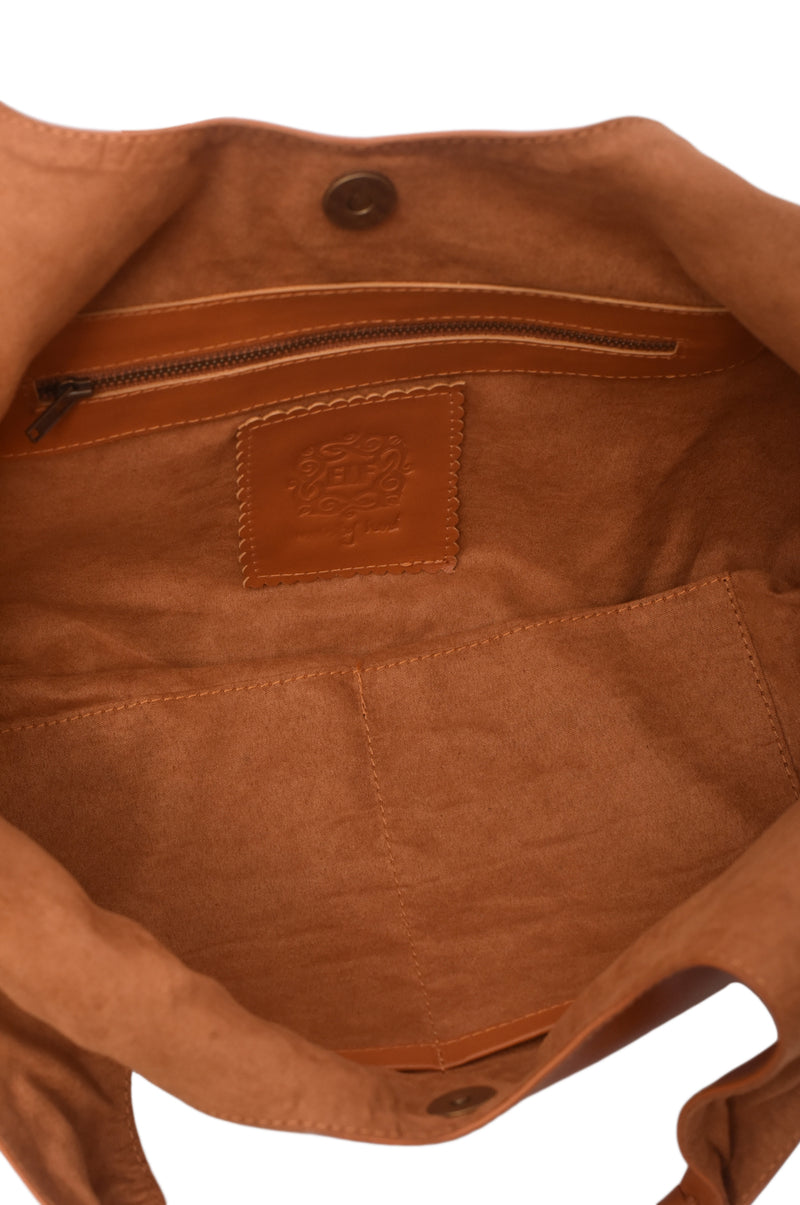 Close-up of a brown leather bag with a visible brand logo on a white background