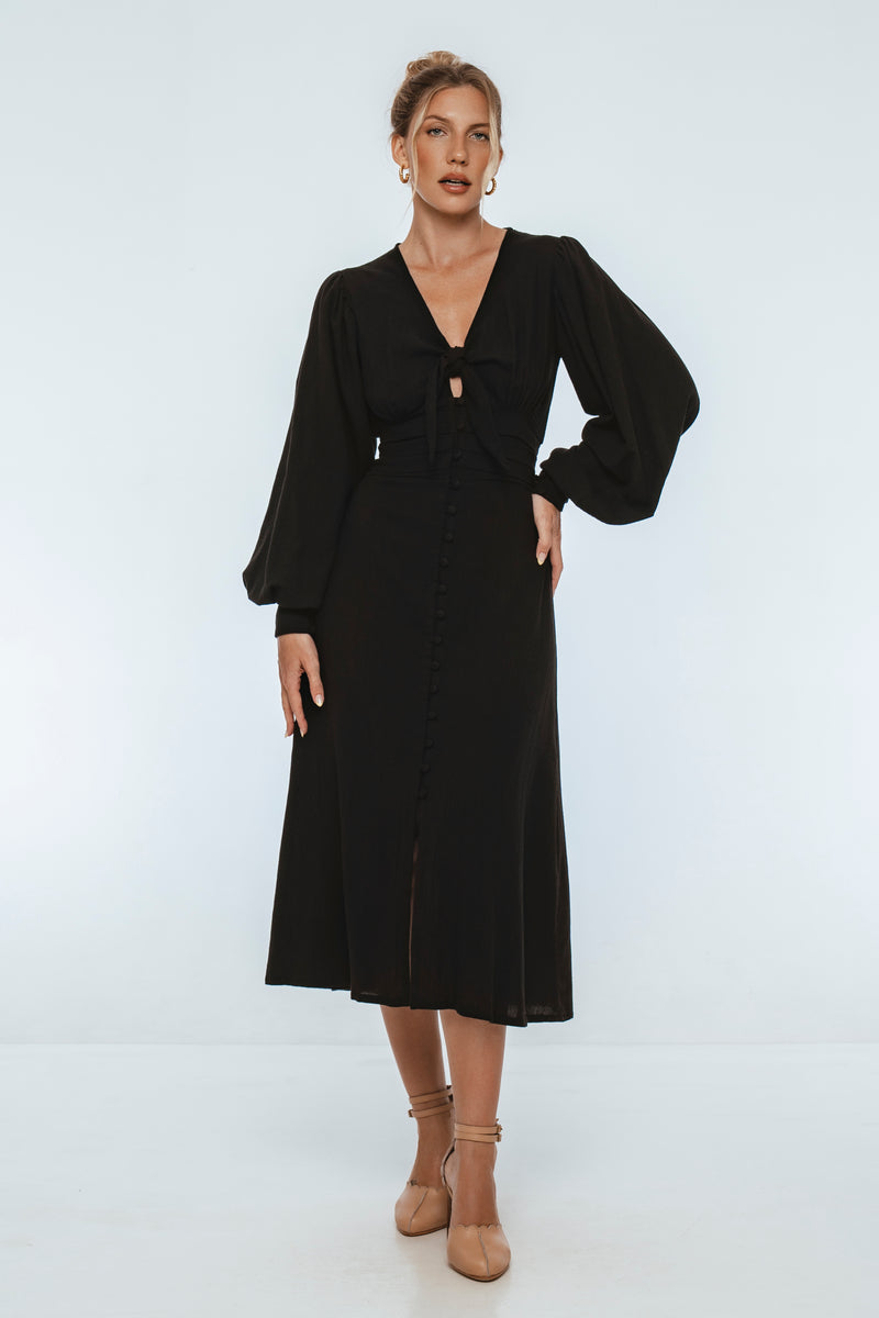 Woman wearing a black dress against a white background